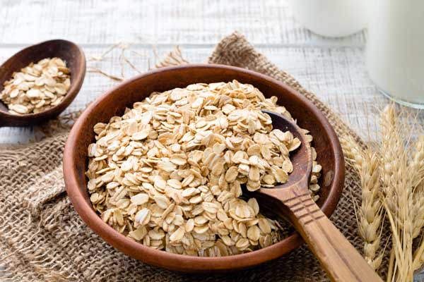A wooden bowl of rolled oats